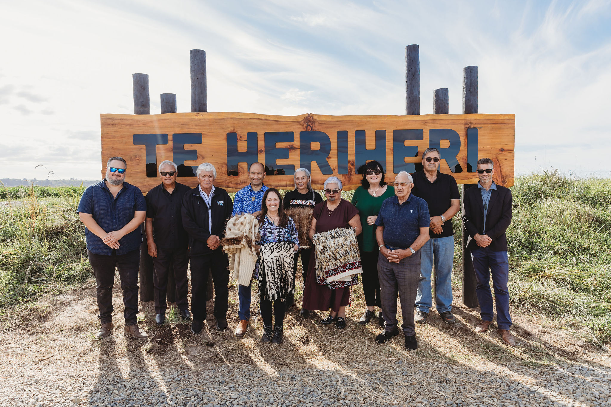 People standing in front of the Te Heriheri wetland sign